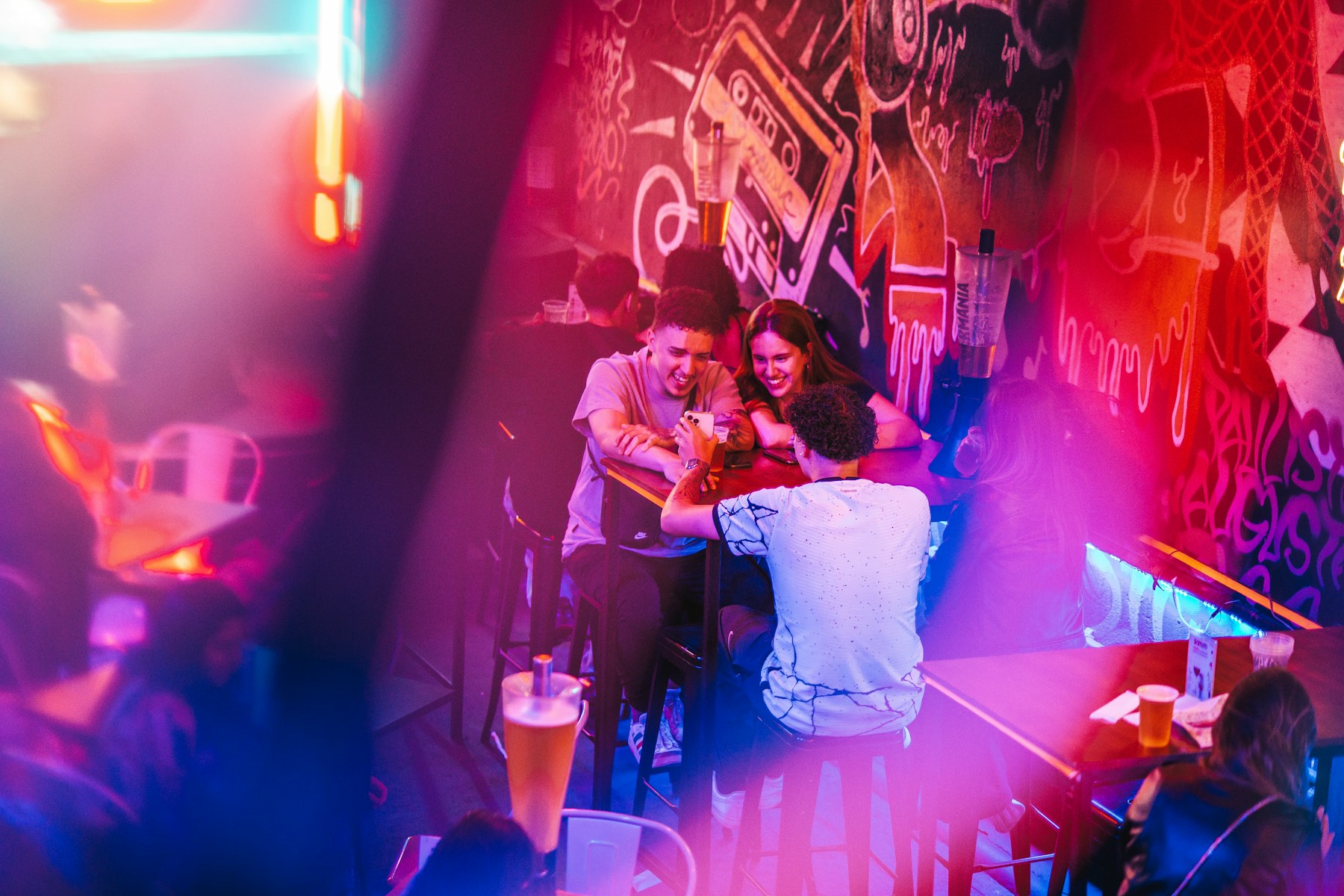 Erwachsene unterhalten sich in einer Bar mit violettem Licht